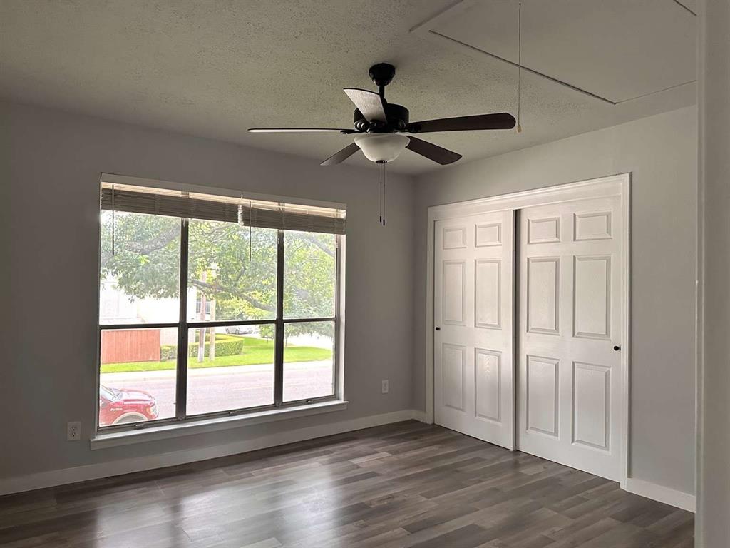 10526 Stone Canyon Road, Unit 201 Dallas, TX 75230 - Photo 14 of 21 a view of an empty room with a window and wooden floor