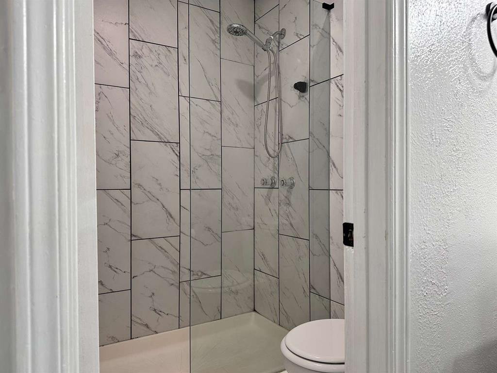 10526 Stone Canyon Road, Unit 201 Dallas, TX 75230 - Photo 17 of 21 a bathroom with a toilet and shower