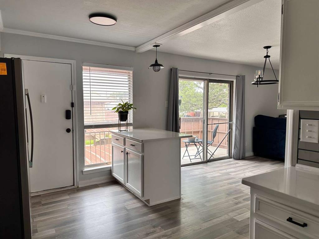 10526 Stone Canyon Road, Unit 201 Dallas, TX 75230 - Photo 4 of 21 a kitchen with stainless steel appliances granite countertop a refrigerator a sink dishwasher a stove and white countertops with wooden floor
