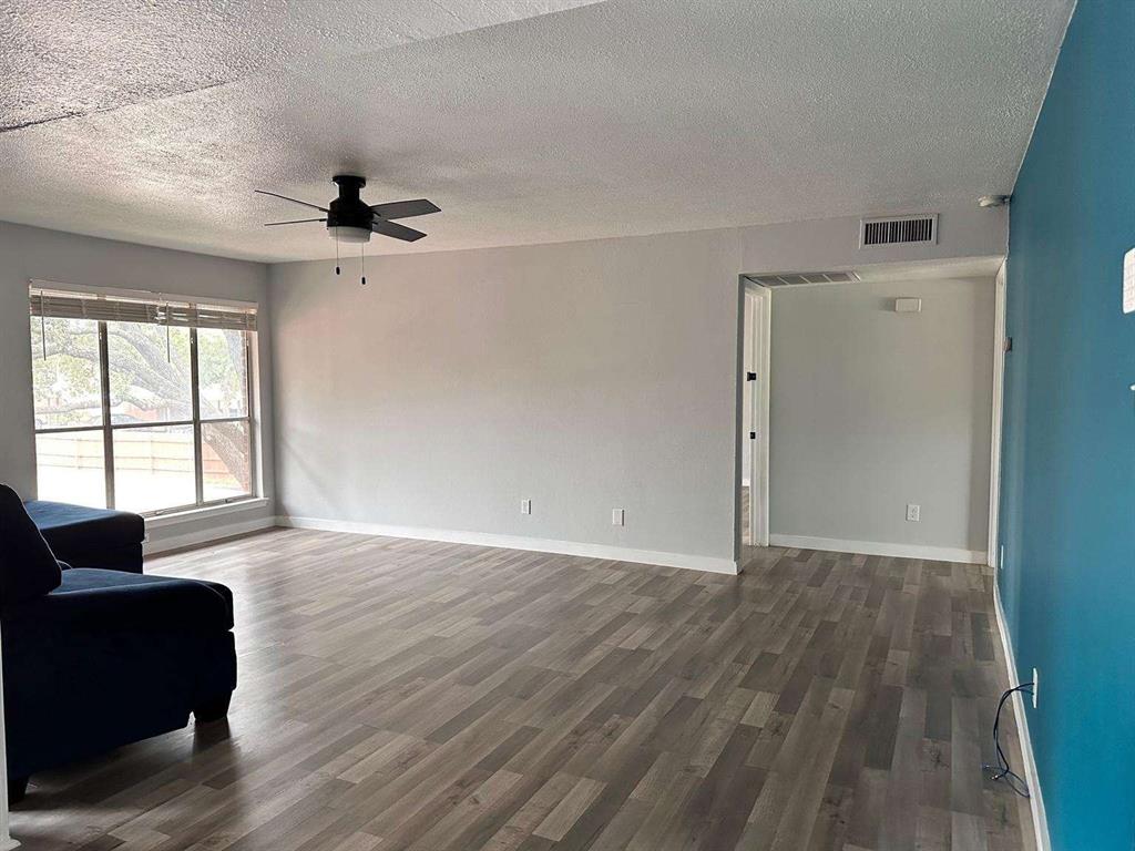 10526 Stone Canyon Road, Unit 201 Dallas, TX 75230 - Photo 7 of 21 a view of an empty room with a window and wooden floor