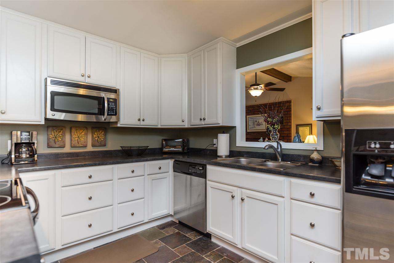 6405 Johnsdale Road Raleigh, NC 27615 - Photo 11 of 25 a kitchen with granite countertop white cabinets stainless steel appliances and a sink