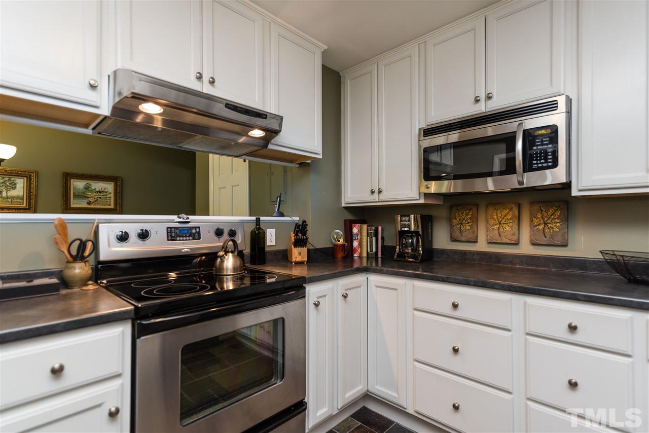 6405 Johnsdale Road Raleigh, NC 27615 - Photo 12 of 25 a kitchen with stainless steel appliances granite countertop a stove microwave and cabinets