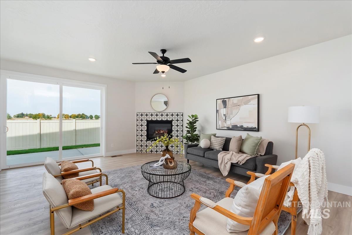 2829 West Warlander Street Meridian, ID 83642 - Photo 4 of 32 Living area featuring light wood-style floors, a tile fireplace, ceiling fan, and recessed lighting