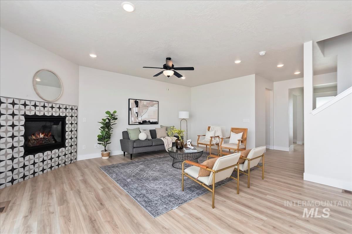 2829 West Warlander Street Meridian, ID 83642 - Photo 7 of 32 Living area with light wood finished floors, ceiling fan, a fireplace, and recessed lighting