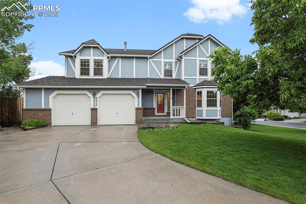 9054 Estebury Circle Colorado Springs, CO 80920 - Photo 1 of 26 a front view of a house with a garden and trees