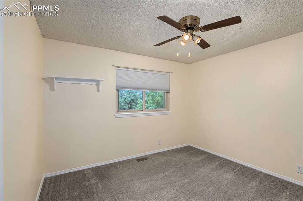 9054 Estebury Circle Colorado Springs, CO 80920 - Photo 12 of 26 an empty room with a window and a ceiling fan