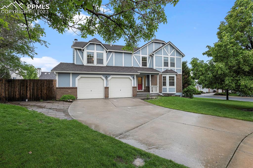 9054 Estebury Circle Colorado Springs, CO 80920 - Photo 2 of 26 a front view of a house with a yard and garage
