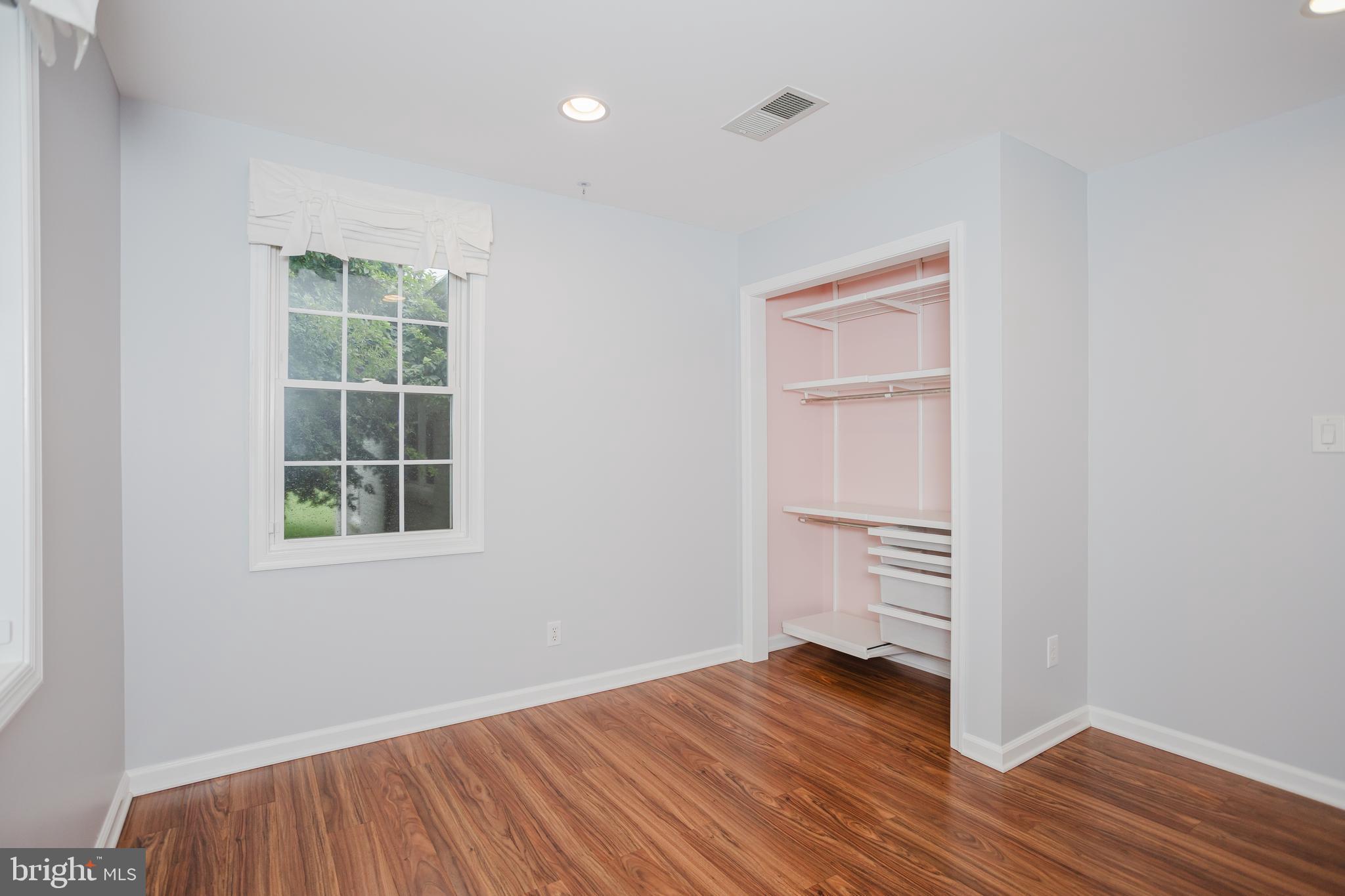 2177 Chain Bridge Road Vienna, VA 22182 - Photo 19 of 48 an empty room with wooden floor cabinet and windows