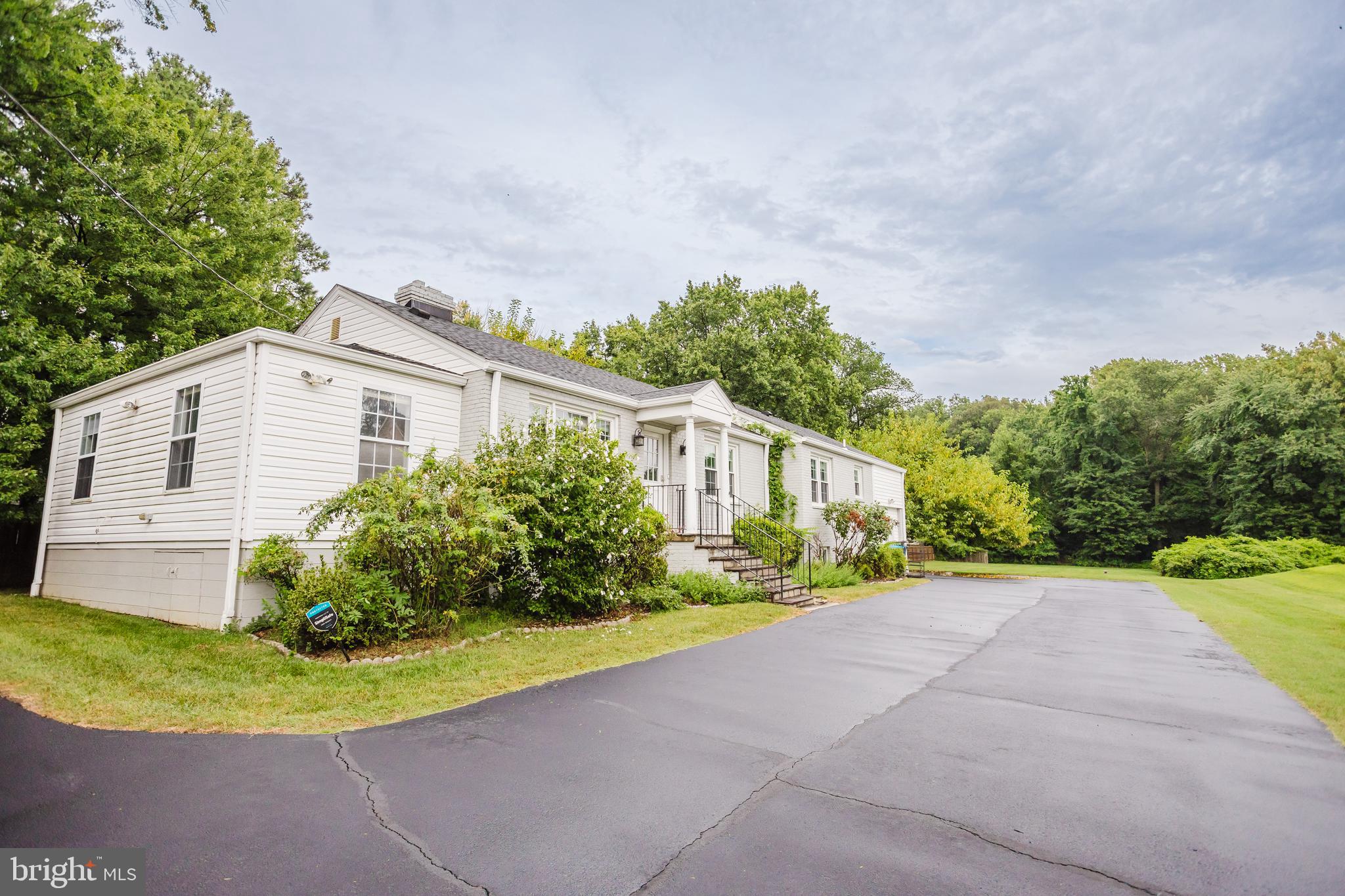 2177 Chain Bridge Road Vienna, VA 22182 - Photo 46 of 48 a view of a white house with a big yard and large tree