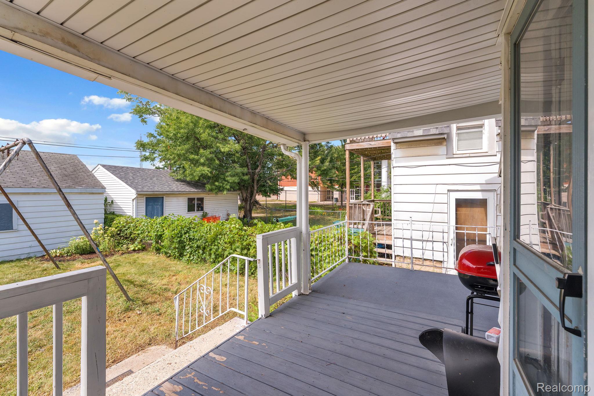 7631 Maple Street Dearborn, MI 48126 - Photo 42 of 48 Covered porch with painted wood decking, white railings, and an overhead awning