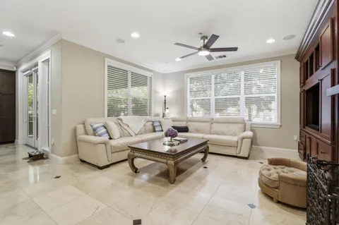 a living room with furniture a flat screen tv and a window
