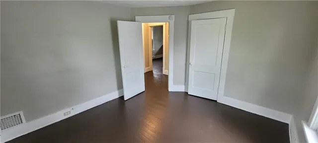 an empty room with wooden floor and closet