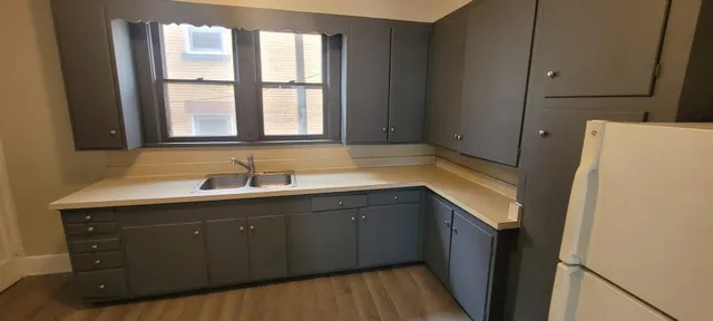 a kitchen with a sink a window and cabinets