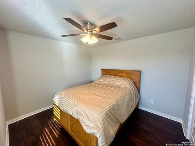 a bedroom with a bed and a ceiling fan