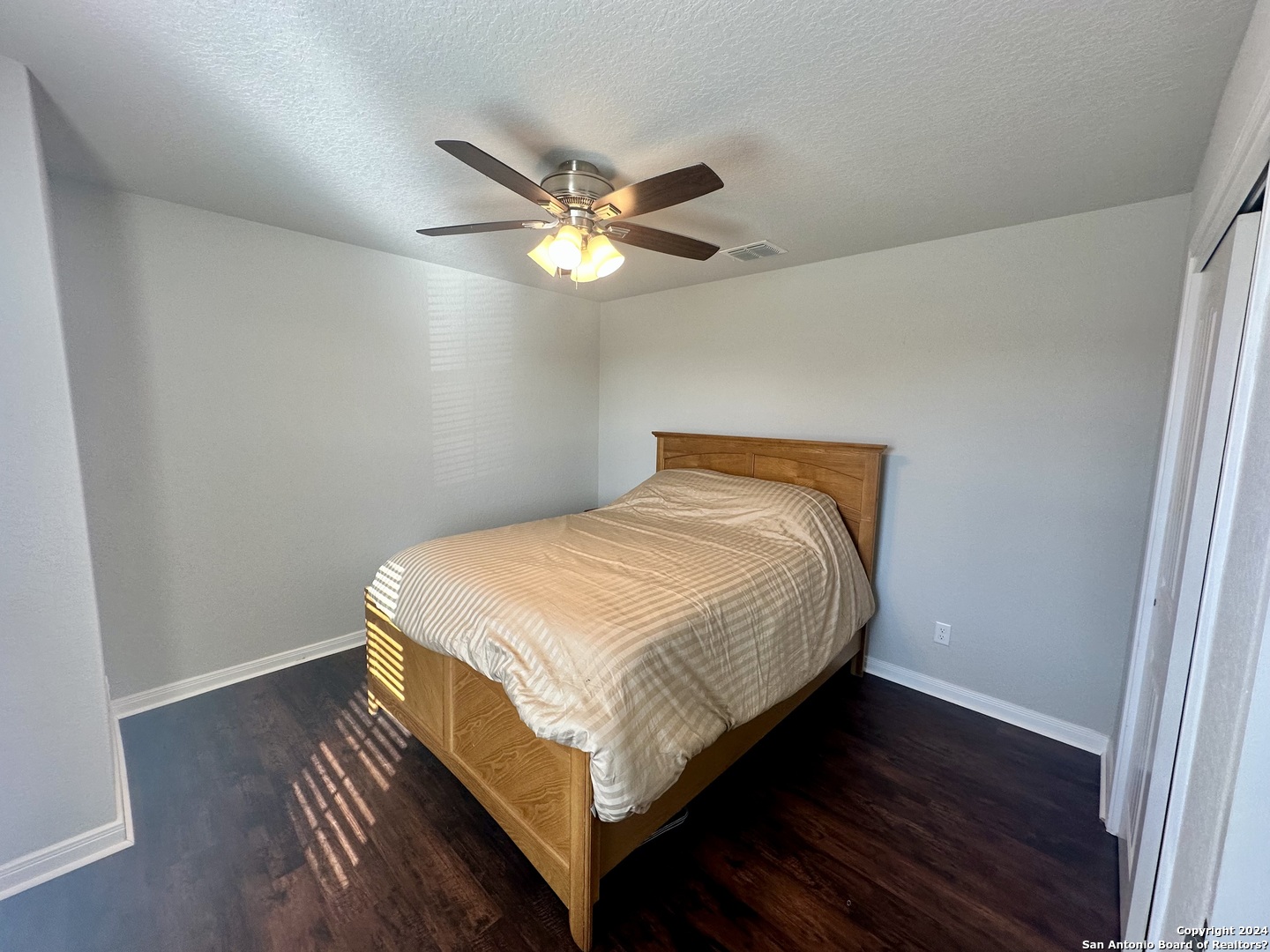 8907 Portobello Converse, TX 78109 - Photo 18 of 26 a bedroom with a bed and wooden floor