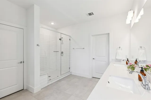 a spacious bathroom with a tub shower and a sink