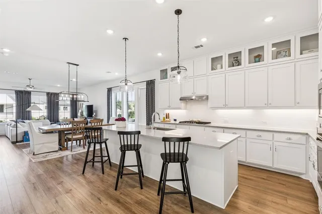 a kitchen with a table chairs stove and white cabinets