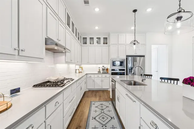 a large kitchen with stainless steel appliances lots of counter space and a sink