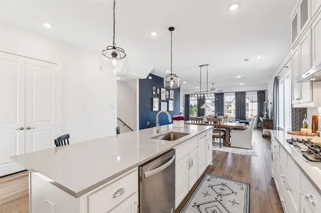 a large kitchen with kitchen island a large counter space a sink appliances and a chandelier