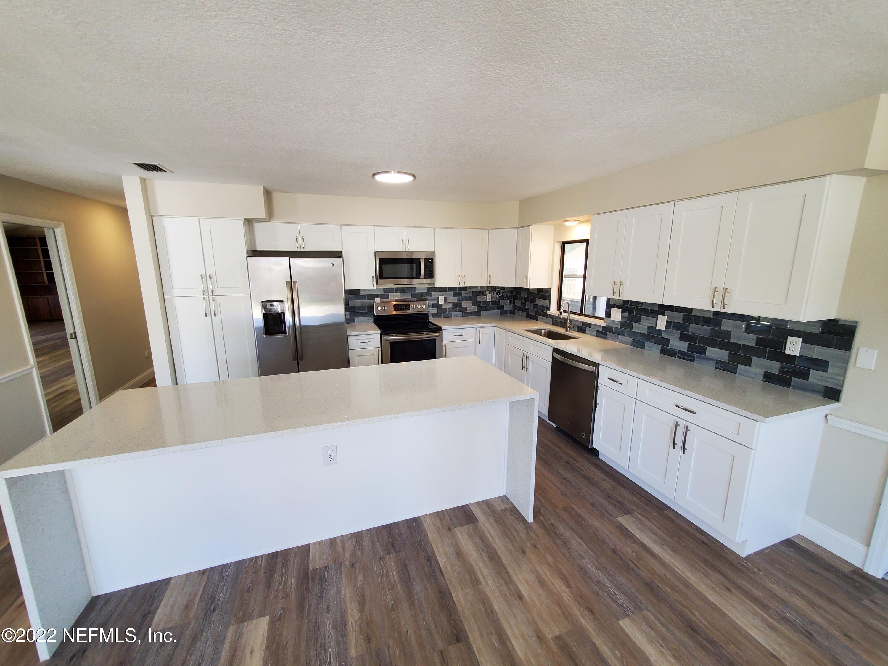111 Nautilus Road St. Augustine, FL 32086 - Photo 11 of 35 a kitchen with stainless steel appliances a refrigerator a stove a sink and white cabinets