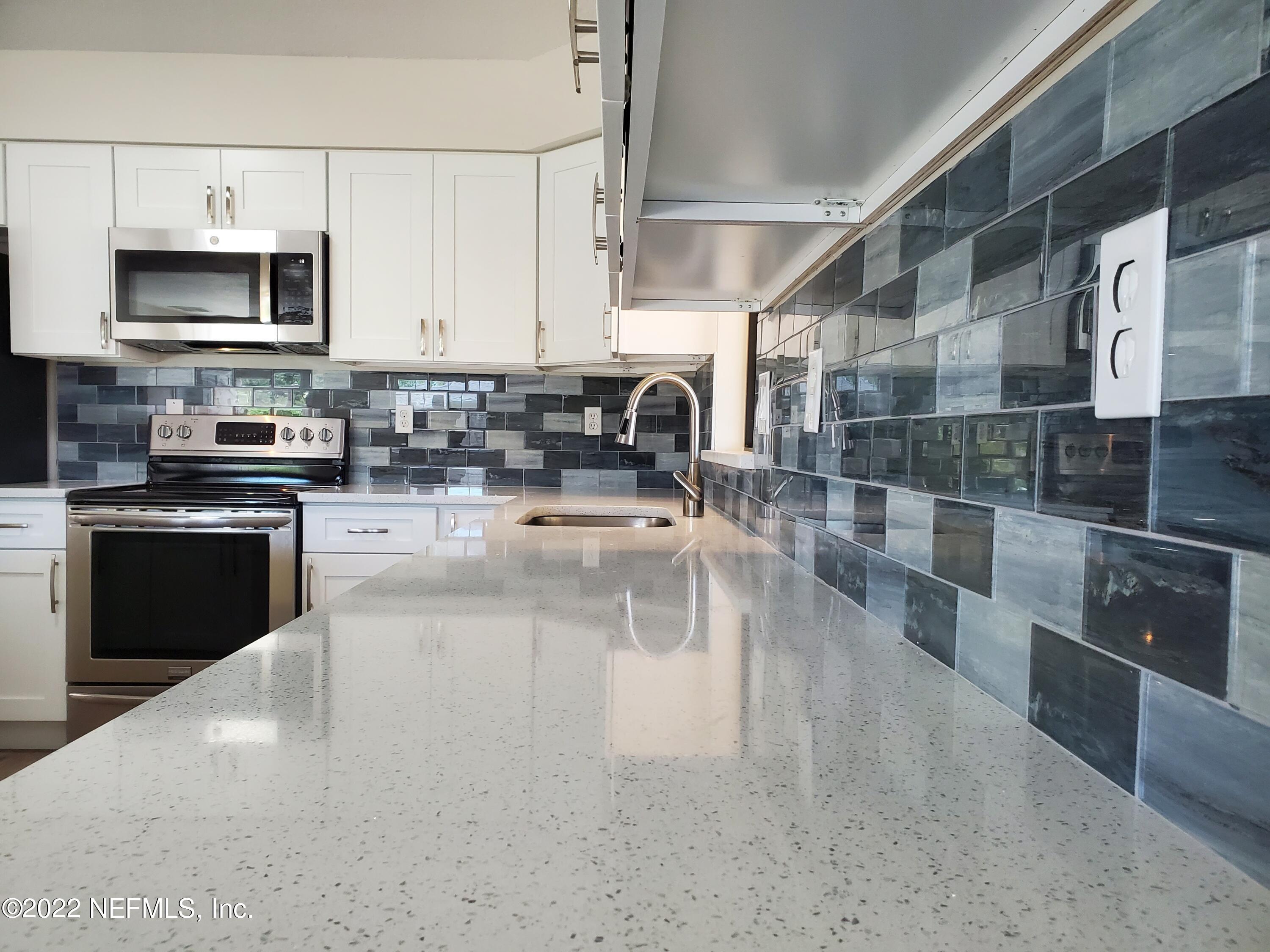 111 Nautilus Road St. Augustine, FL 32086 - Photo 13 of 35 a kitchen with stainless steel appliances granite countertop a sink a stove and a microwave