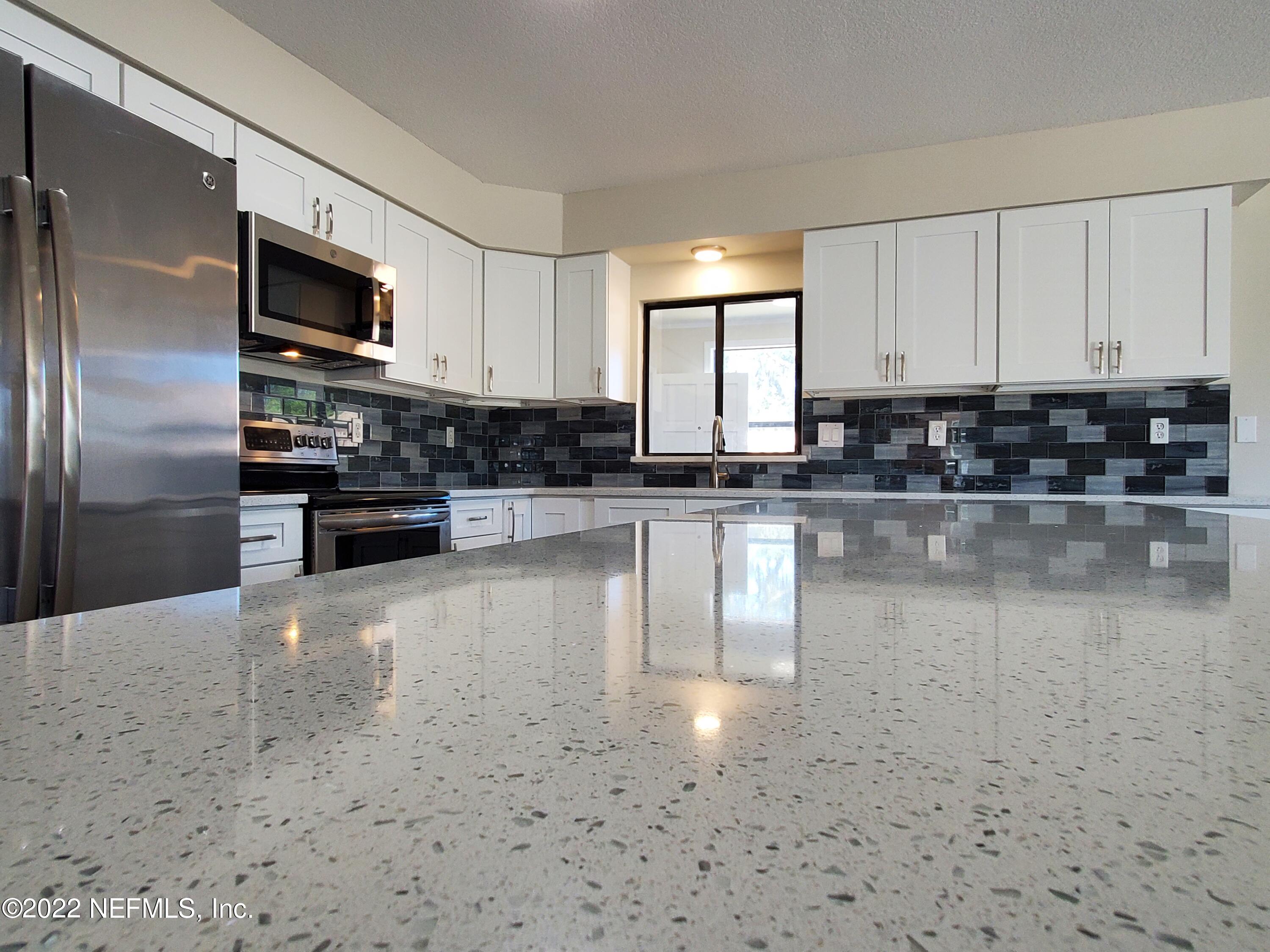 111 Nautilus Road St. Augustine, FL 32086 - Photo 14 of 35 a kitchen with stainless steel appliances a refrigerator a stove a microwave and cabinets