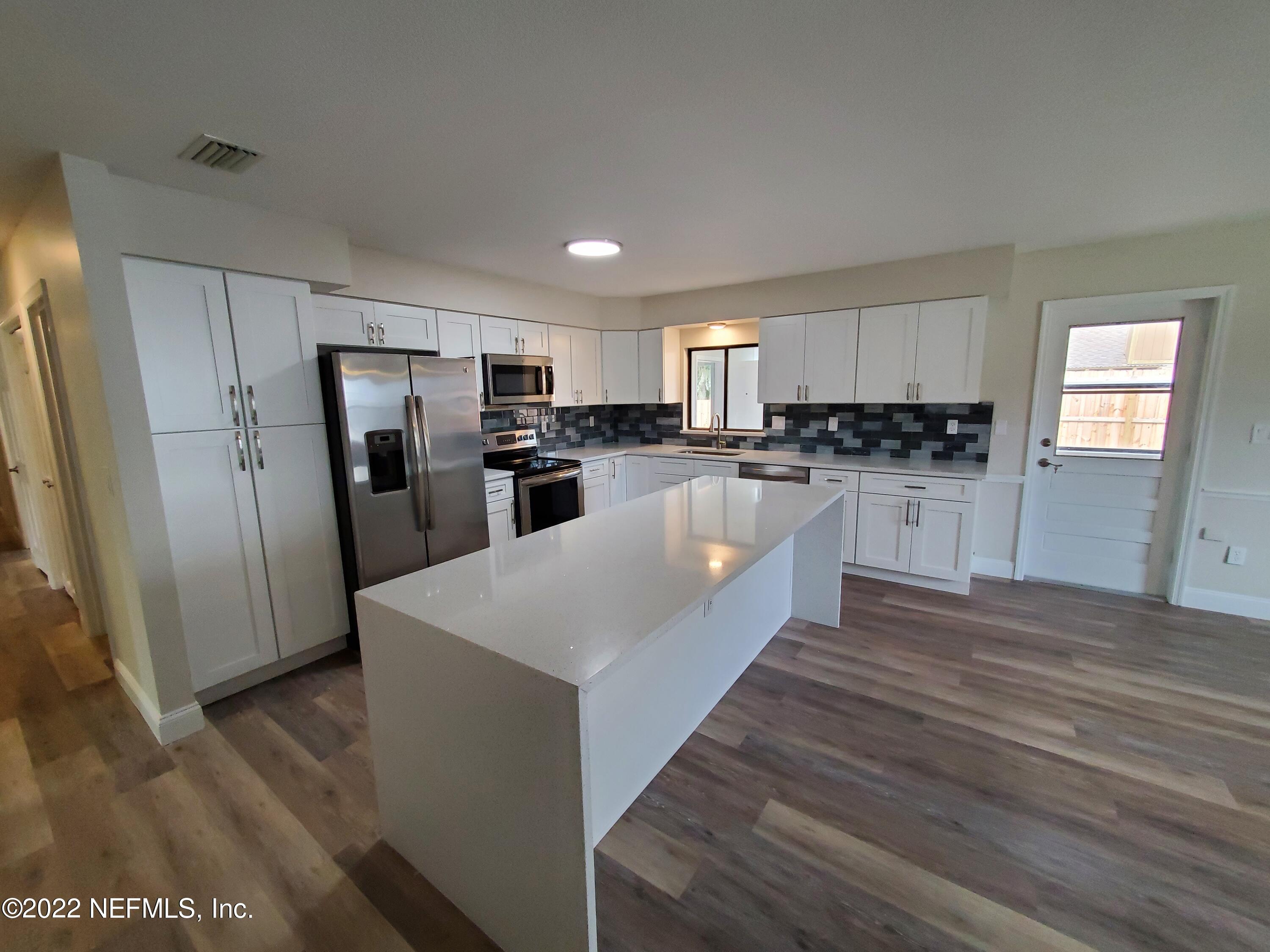111 Nautilus Road St. Augustine, FL 32086 - Photo 15 of 35 a large kitchen with cabinets wooden floor and stainless steel appliances