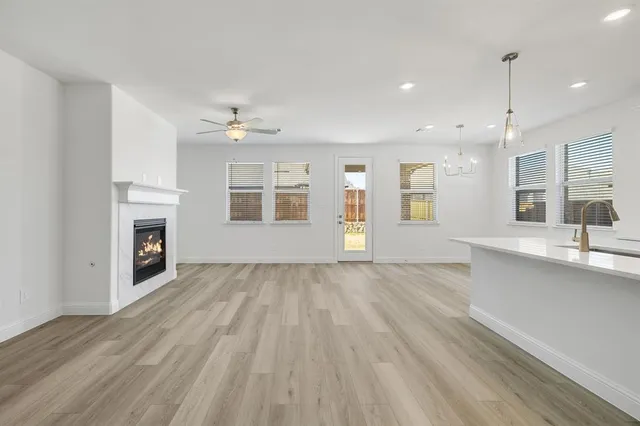 a large white kitchen with kitchen island a sink dishwasher and a stove with wooden floors
