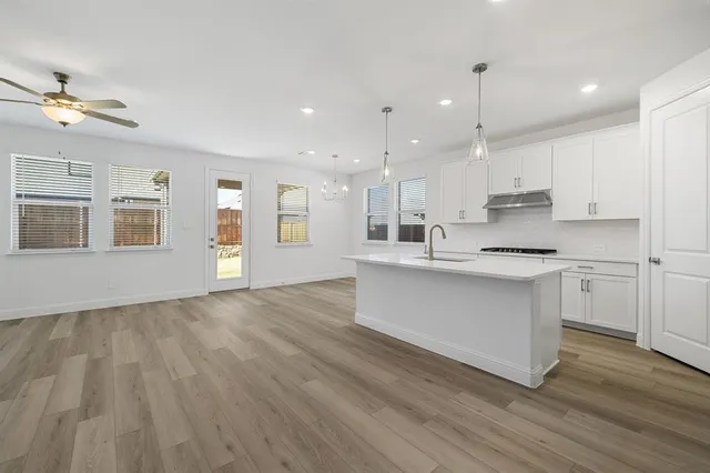 a large kitchen with stainless steel appliances kitchen island a large counter top and a refrigerator