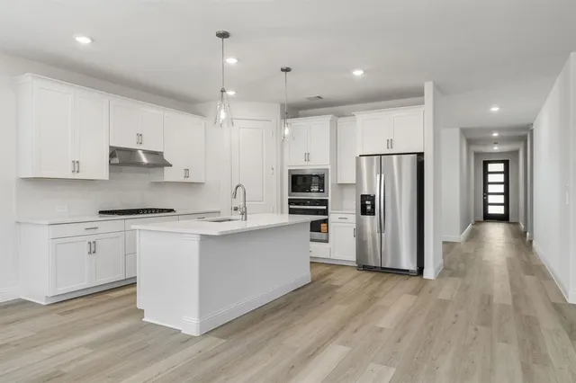 a large kitchen with a lot of cabinets and stainless steel appliances