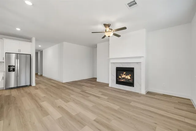a kitchen with kitchen island a white counter top space stainless steel appliances and cabinets
