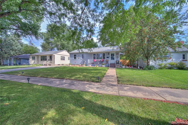 a view of big yard in front of house with large trees