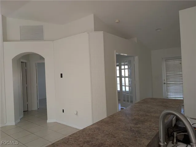 a kitchen with granite countertop a sink a counter top space and cabinets