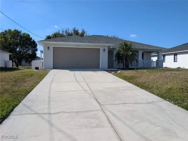 a front view of a house with a yard and a garage