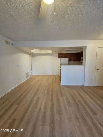 a view of empty room with wooden floor