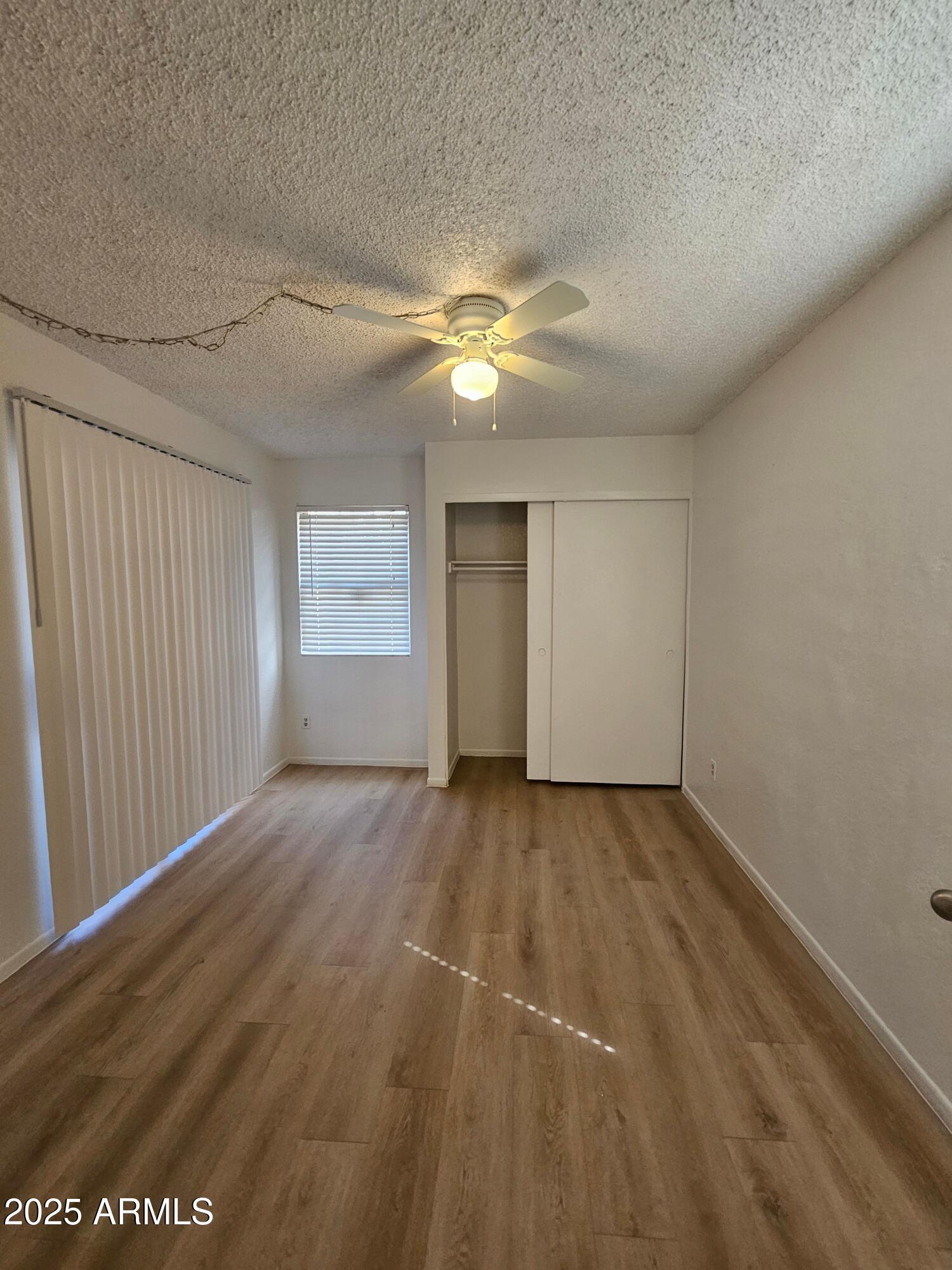 1370 South Price Road, Unit 101 Tempe, AZ 85281 - Photo 7 of 11 wooden floor in an empty room with a window