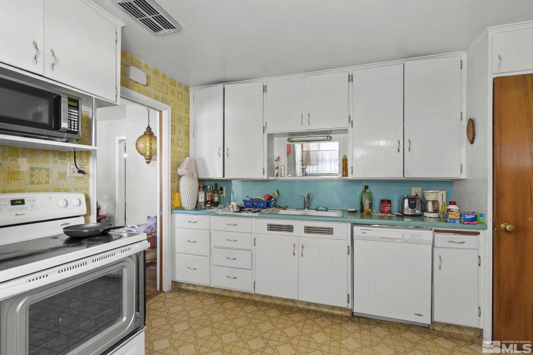 655 Belgrave Avenue Reno, NV 89502 - Photo 7 of 17 a kitchen with stainless steel appliances granite countertop a stove a sink and a microwave