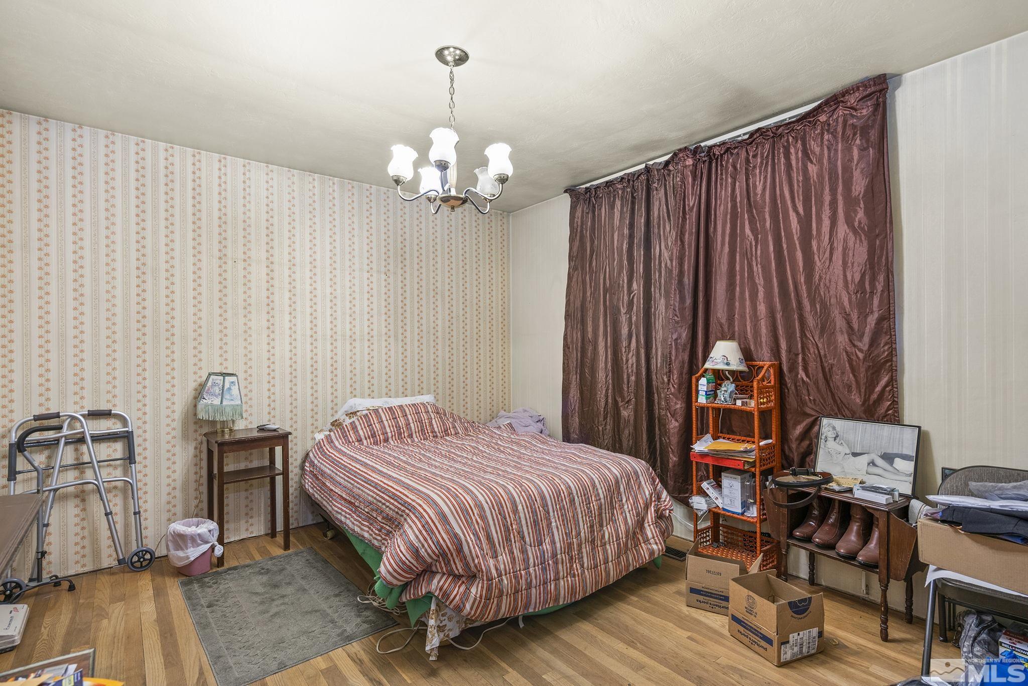 655 Belgrave Avenue Reno, NV 89502 - Photo 8 of 17 a spacious bedroom with a bed and a chandelier