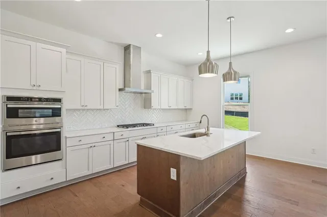 a kitchen with a stove a sink a center island and windows