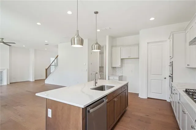 a kitchen with a sink a center island a counter space and a refrigerator