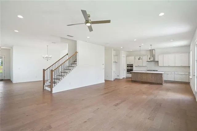 a view of kitchen and kitchen with stainless steel appliances wooden floor