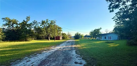 a view of a big yard with a large trees
