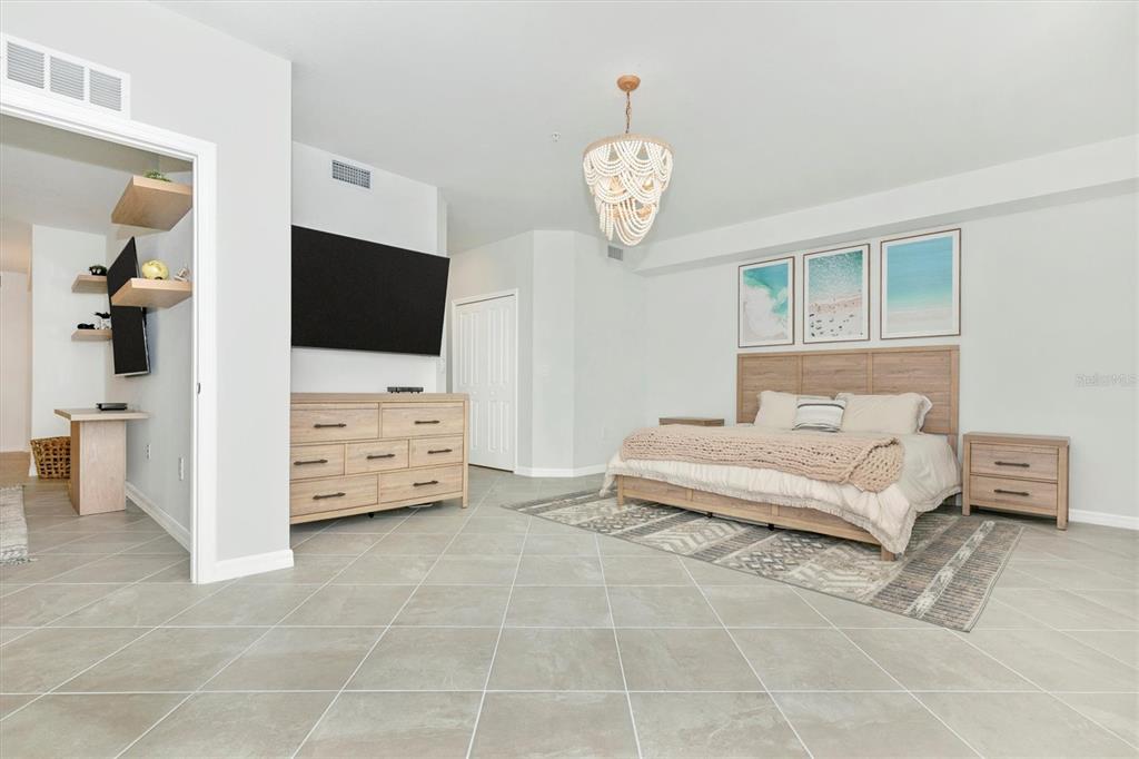 12625 Radiance Court, Unit 102 Venice, FL 34293 - Photo 30 of 99 a spacious bedroom with a bed and a television