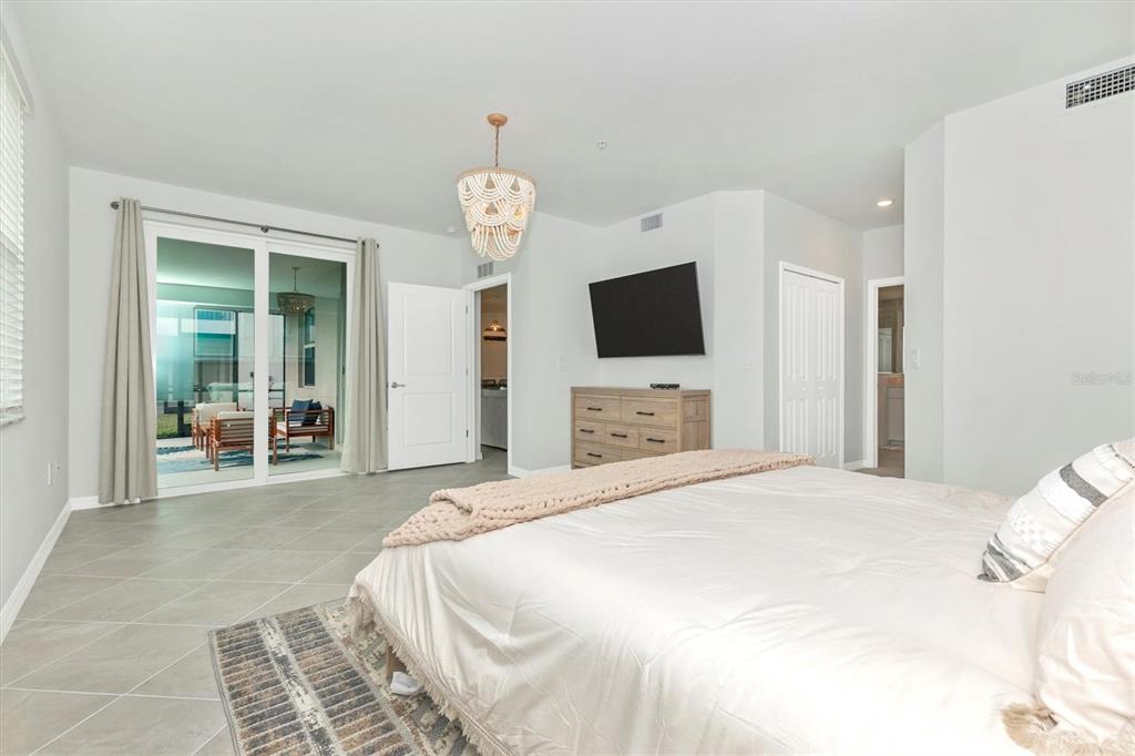 12625 Radiance Court, Unit 102 Venice, FL 34293 - Photo 31 of 99 a spacious bedroom with a bed and a flat screen tv