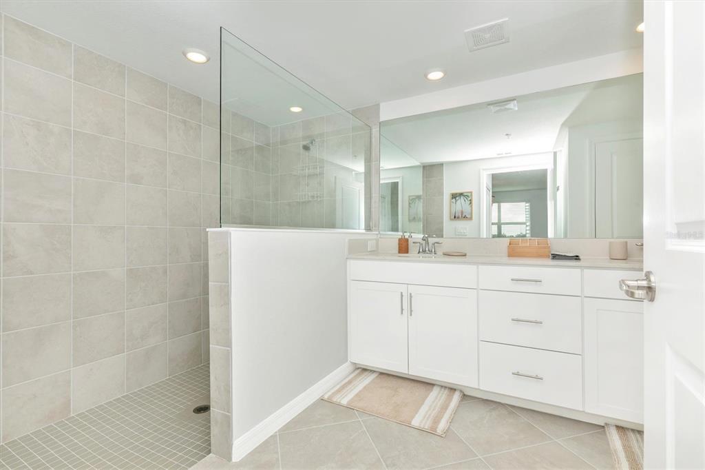 12625 Radiance Court, Unit 102 Venice, FL 34293 - Photo 35 of 99 a bathroom with a double vanity sink mirror and shower