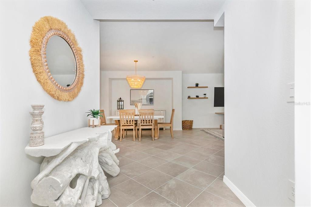 12625 Radiance Court, Unit 102 Venice, FL 34293 - Photo 4 of 99 a living room with furniture a mirror and a dining table