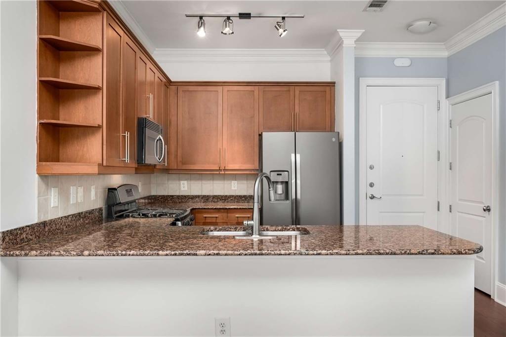 1055 Piedmont Avenue Northeast, Unit 114 Atlanta, GA 30309 - Photo 11 of 40 a kitchen with granite countertop a refrigerator a stove and a sink
