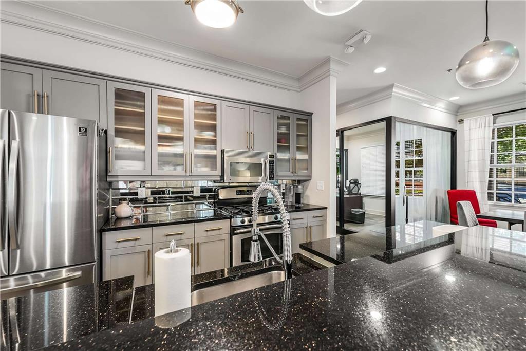 1055 Piedmont Avenue Northeast, Unit 114 Atlanta, GA 30309 - Photo 26 of 40 a kitchen with stainless steel appliances granite countertop a stove and a refrigerator