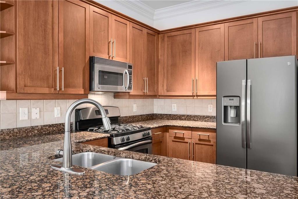 1055 Piedmont Avenue Northeast, Unit 114 Atlanta, GA 30309 - Photo 8 of 40 a kitchen with stainless steel appliances granite countertop a refrigerator sink and stove