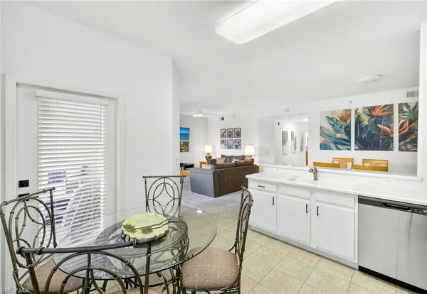 a kitchen with stainless steel appliances a table chairs and a refrigerator
